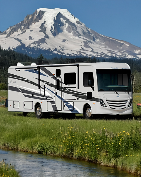 Class A motorhome parked near Mount Hood with reflection in water