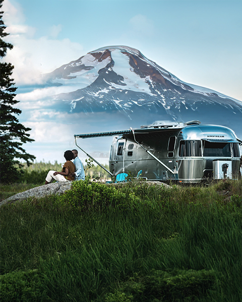 Travel trailer with Mount Rainier in the background at a campsite