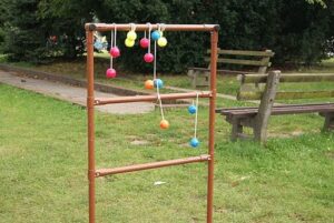 Ladder golf game setup on green grass at a campsite.